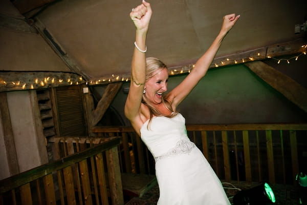 Bride with arms raised - A Beautiful Garden Party Wedding at Lains Barn