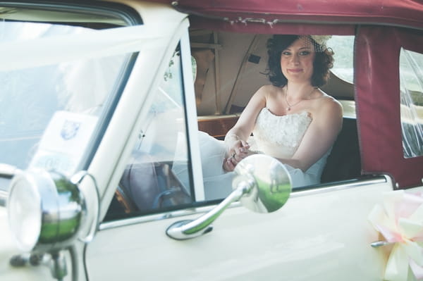 Bride sitting in back of wedding car - A Farm Wedding with a British Summer Theme