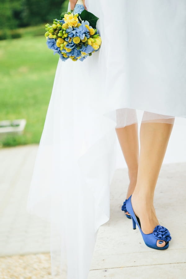 Bride's legs wearing blue shoes - A Spring Themed Wedding in Hungary