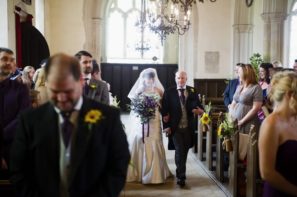 Bride walking into church with father