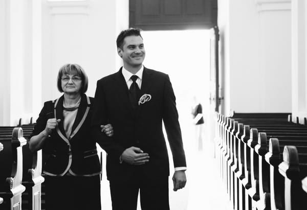 Groom walking into church with mother - A Spring Themed Wedding in Hungary