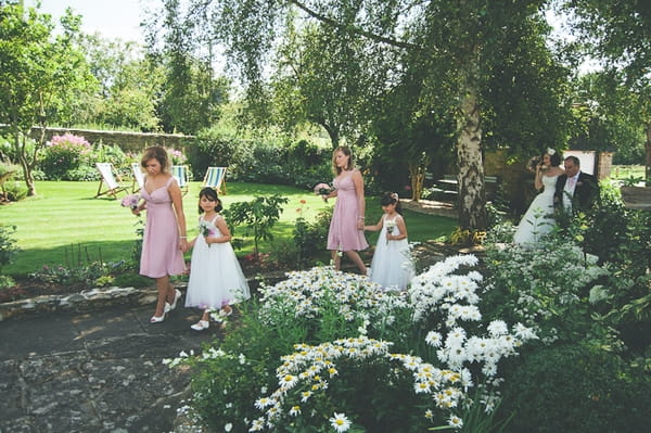 Bridesmaids walking through garden - A Farm Wedding with a British Summer Theme