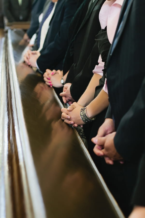 Hands clasped in church - A Spring Themed Wedding in Hungary