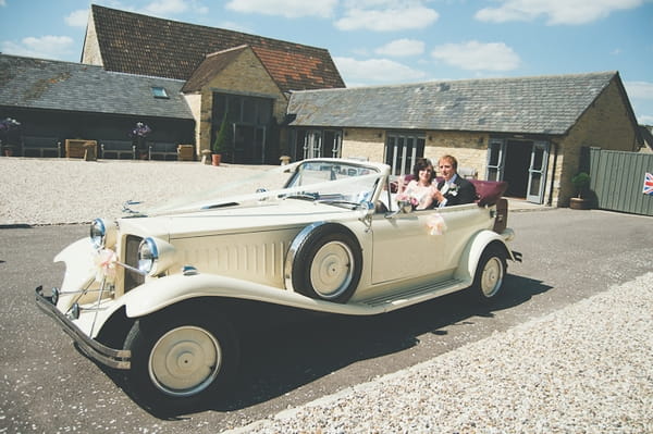 Bride and groom sitting in Beauford wedding car - A Farm Wedding with a British Summer Theme