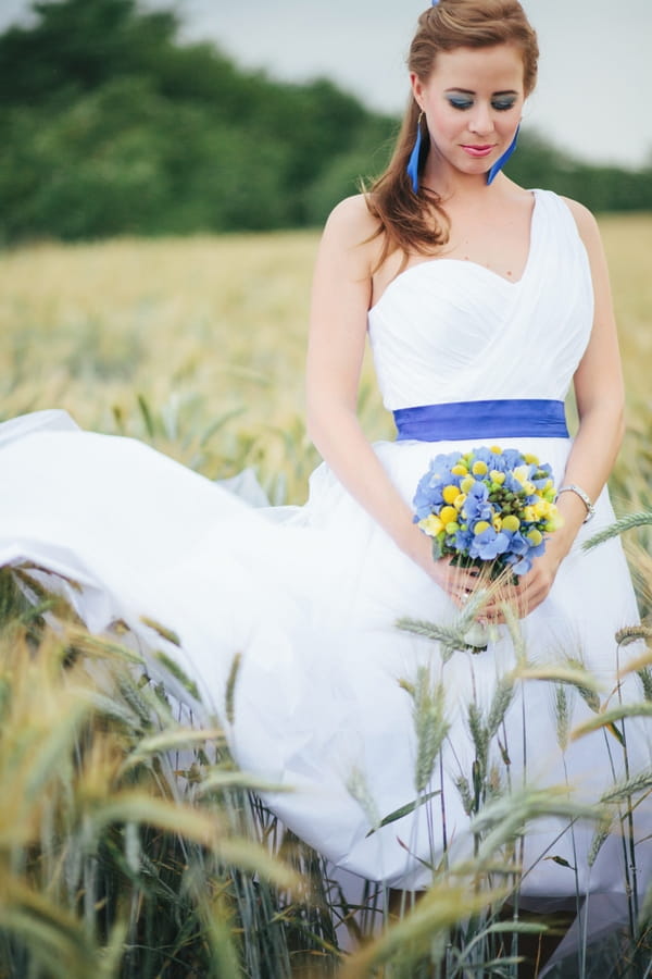 Bride standing in corn field - A Spring Themed Wedding in Hungary