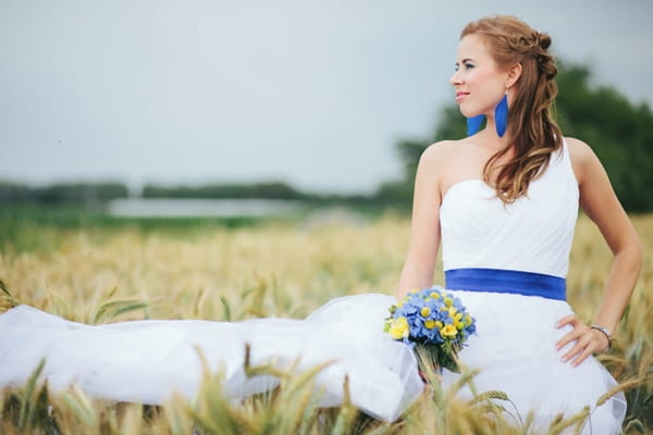 Bride with hand on hip in corn field - A Spring Themed Wedding in Hungary