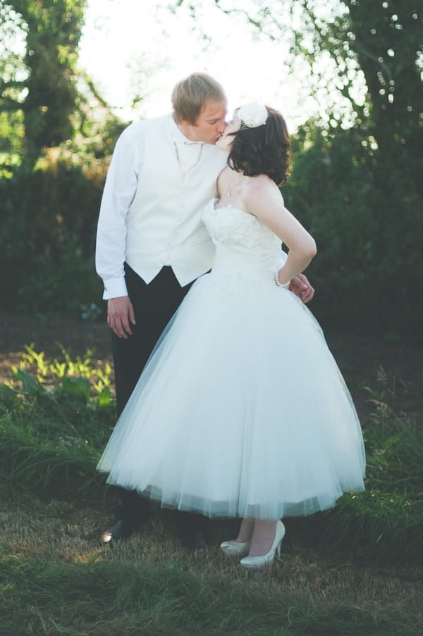 Bride and groom kissing - A Farm Wedding with a British Summer Theme