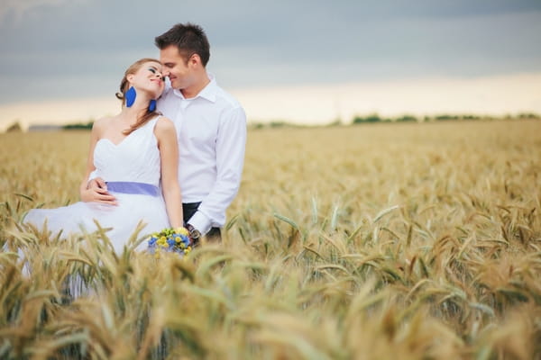 Bride and groom posing in corn field - A Spring Themed Wedding in Hungary