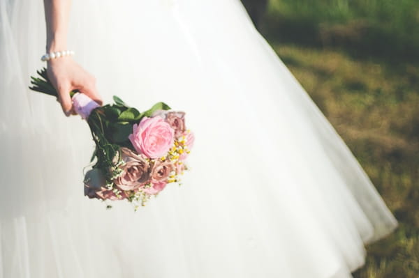 Bride's hand holding bouquet - A Farm Wedding with a British Summer Theme