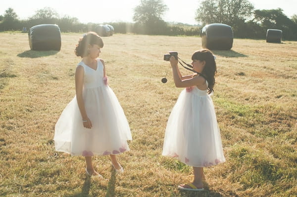 Flower girls playing with camera - A Farm Wedding with a British Summer Theme