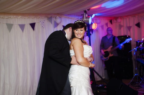 Groom kissing back of bride's neck