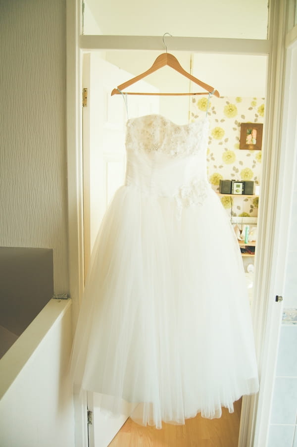 Wedding dress hanging in doorway - A Farm Wedding with a British Summer Theme