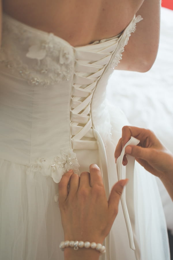 Back of wedding dress being done up - A Farm Wedding with a British Summer Theme