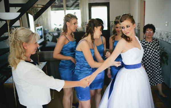 Bride wearing dress with blue ribbon - A Spring Themed Wedding in Hungary