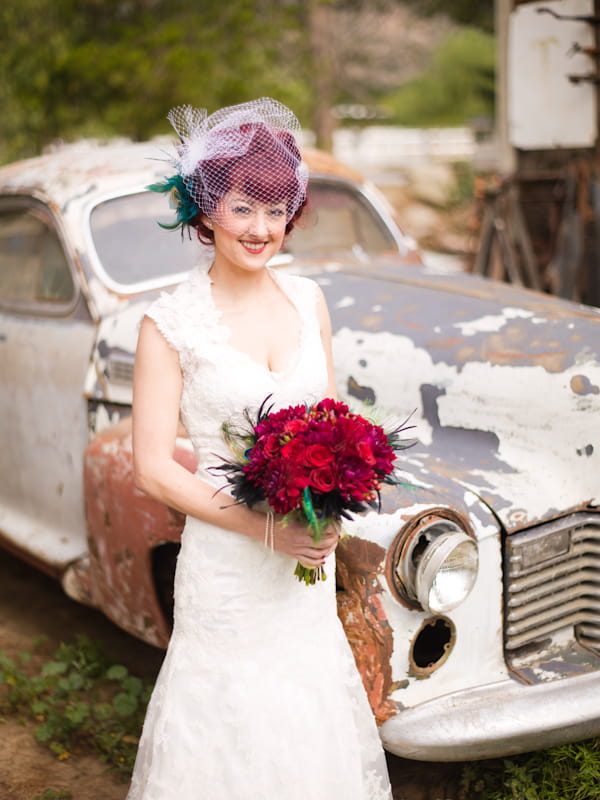 Bride standing in front of old car