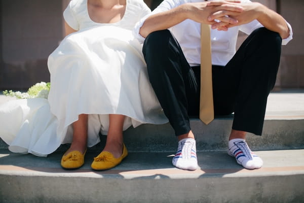 Bride and groom's legs as they are sat down