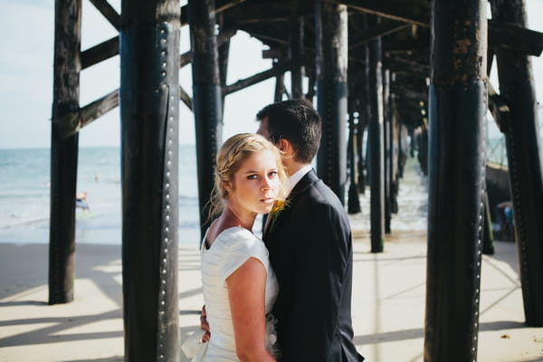 Bride and groom under pier
