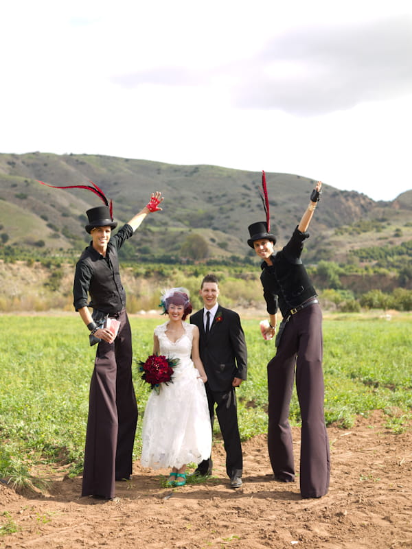 Bride and groom with circus performers on stilts