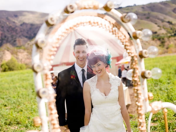 Bride and groom's reflections in circus mirror