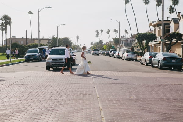 Bride and groom walking across road