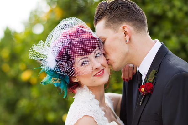 Groom kissing bride on cheek