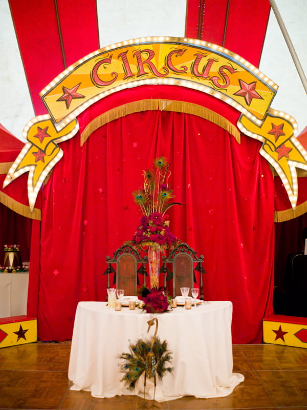 Bride and groom's chairs in front of circus sign