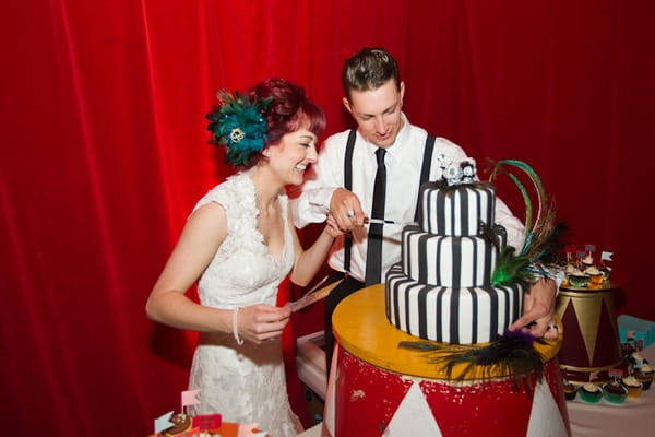 Bride and groom cutting black and white stripe cake