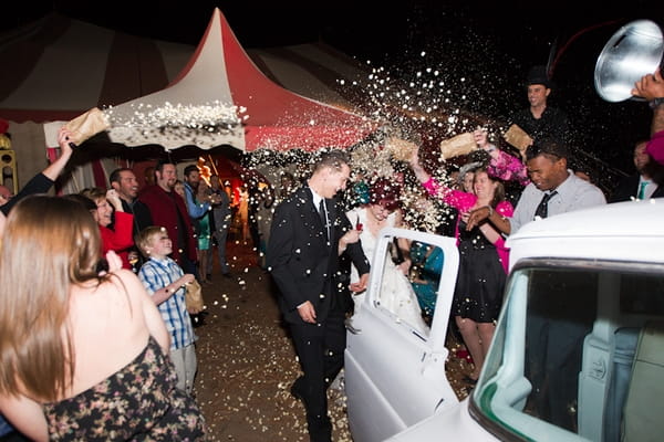 Bride and groom getting into wedding car