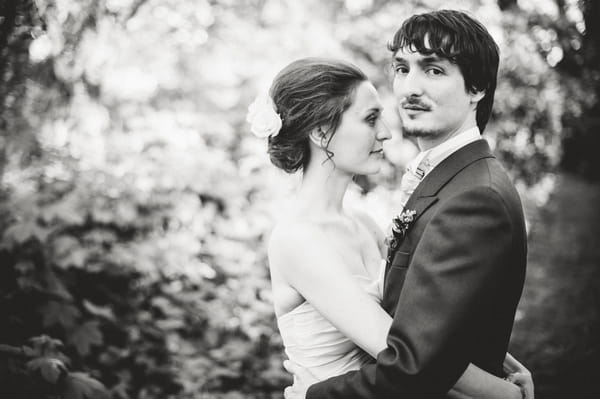 Black and white picture of bride with arms around groom's waist - Picture by Aaron Collett Photography