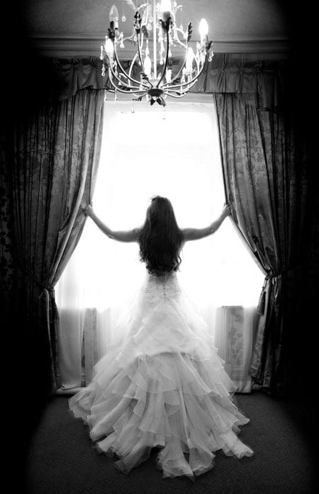 Bride standing looking out of window - Picture by Karli Harrison Photography