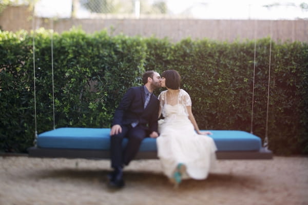 Bride and groom kissing on swing