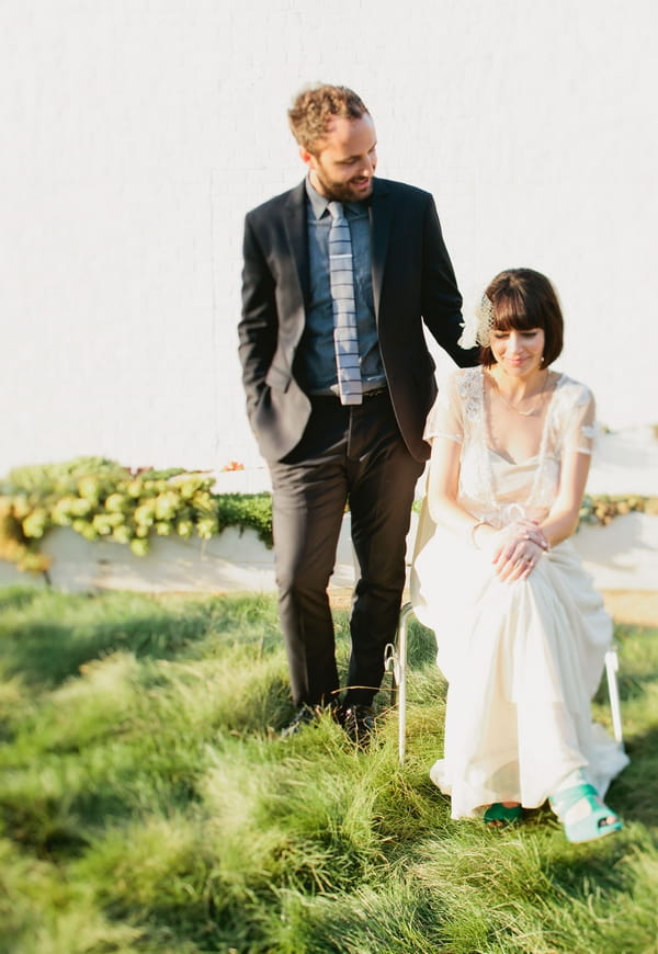 Groom standing over seated bride