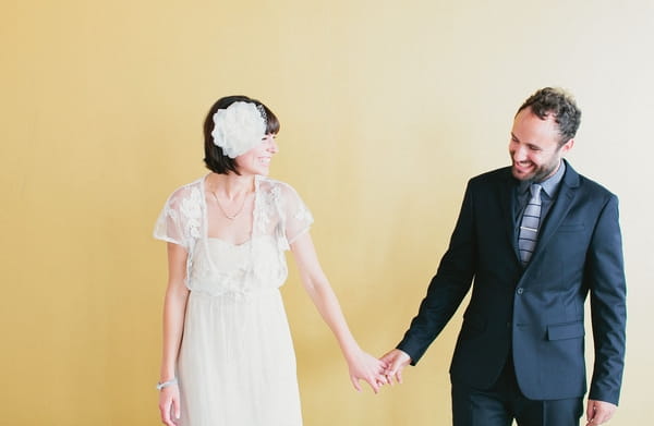 Bride and groom holding hands as groom looks at bride