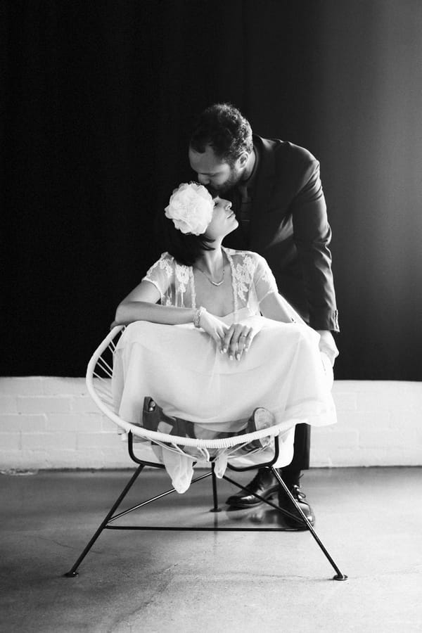 Groom kissing bride on head