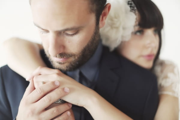 Groom with bride's arms around him