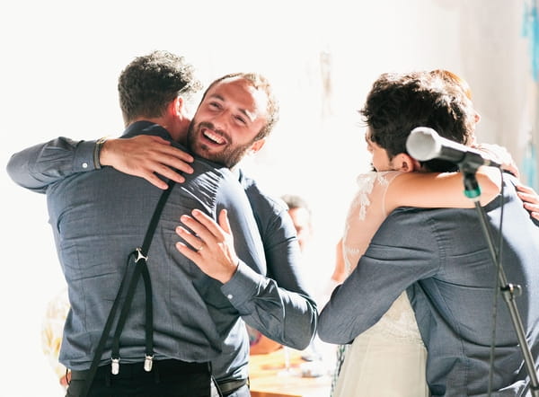 Groom hugging groomsman