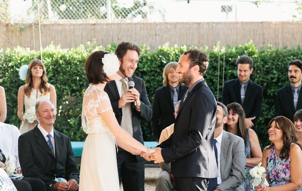 Bride and groom holding hands in wedding ceremony