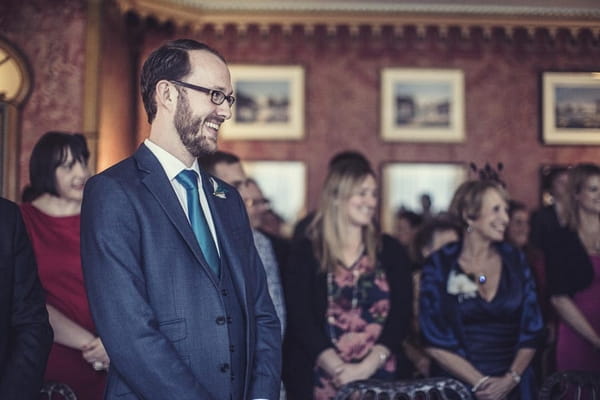 Groom smiling as bride enters wedding ceremony