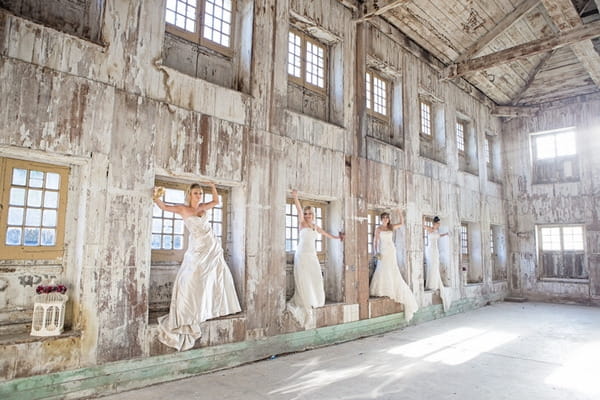 Brides standing in windows of warehouse