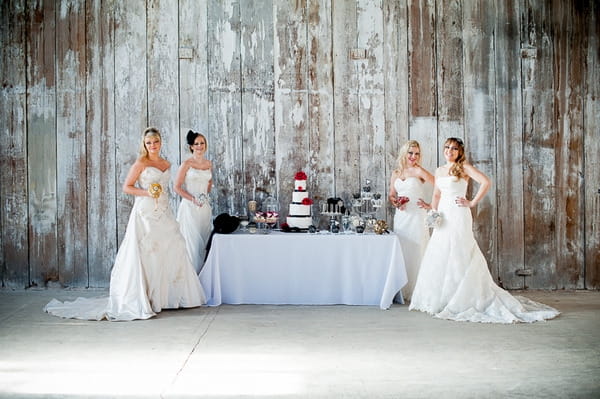 Brides standing by table of wedding cakes