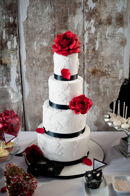 White tiered wedding cake with red and black