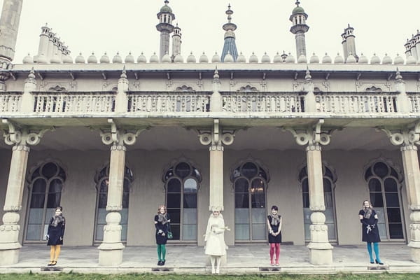 Bride and bridesmaids standing in front of pillars