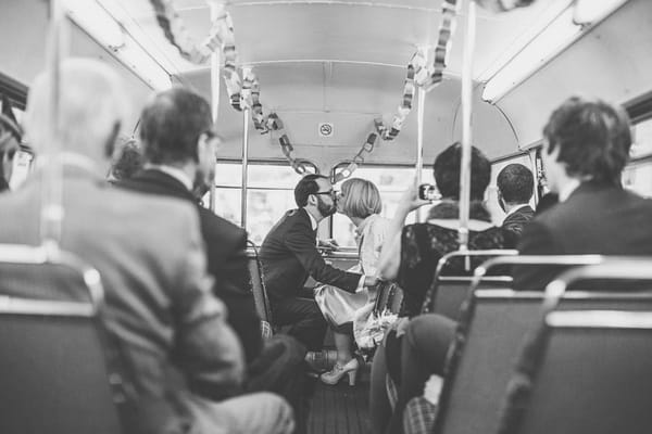 Bride and groom kissing on bus