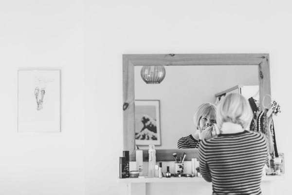 Bride doing make-up in mirror