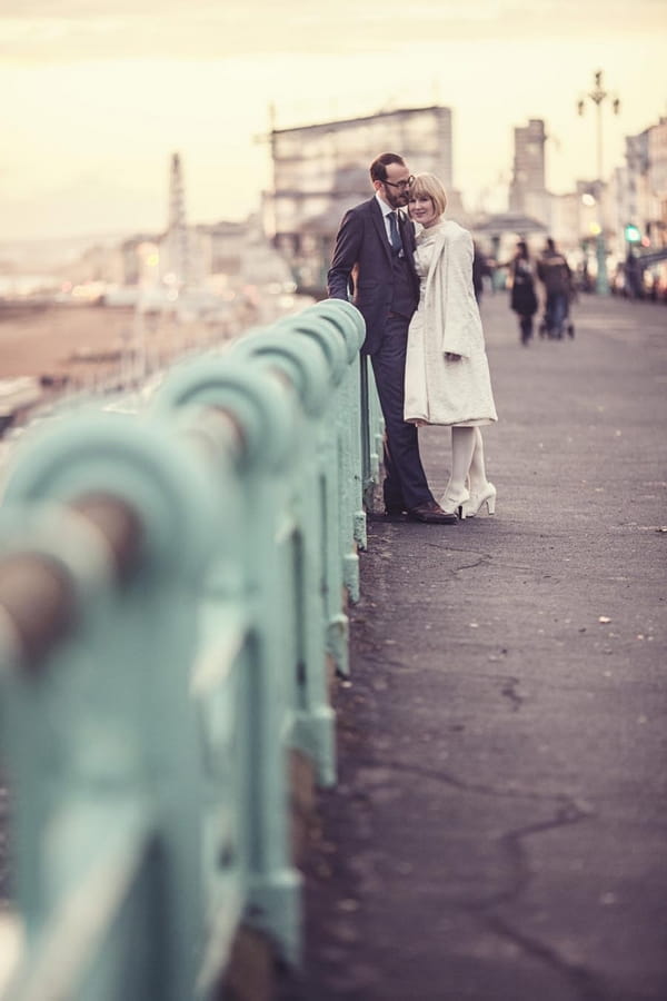 Bride and groom leaning on railings