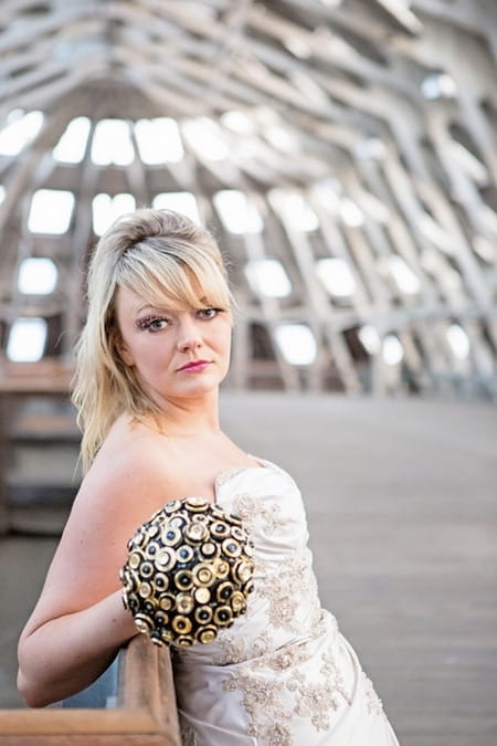 Bride leaning back holding brooch bouquet