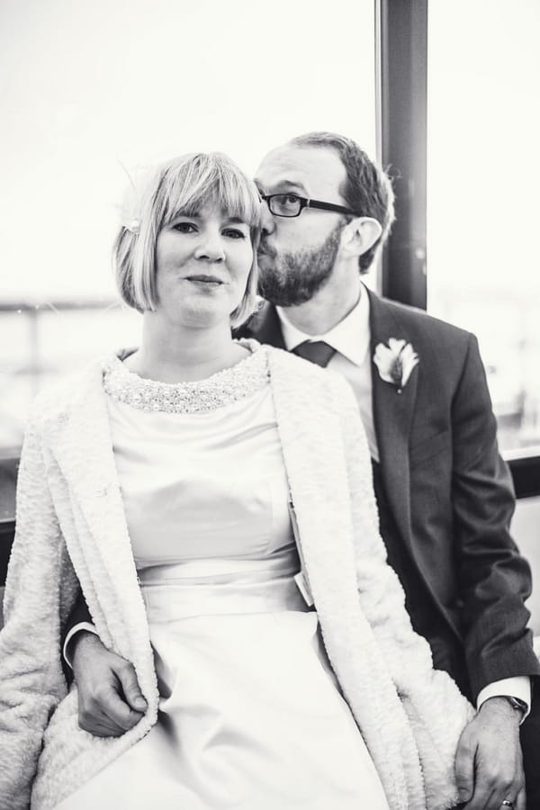 Groom kissing bride's head