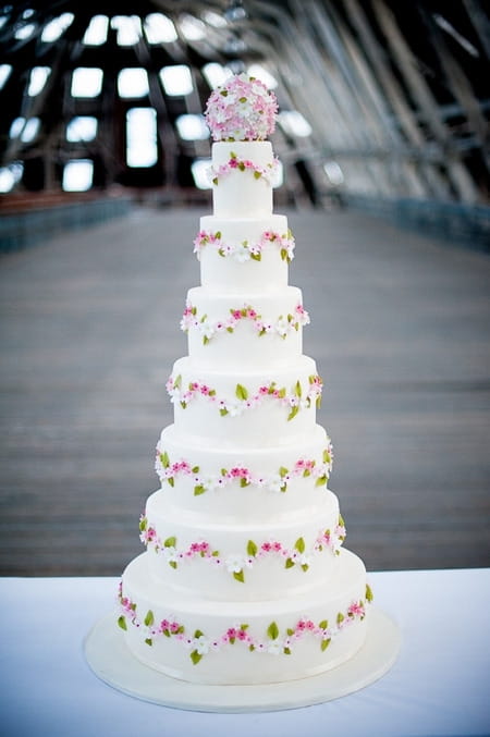 Tall white wedding cake with flower design