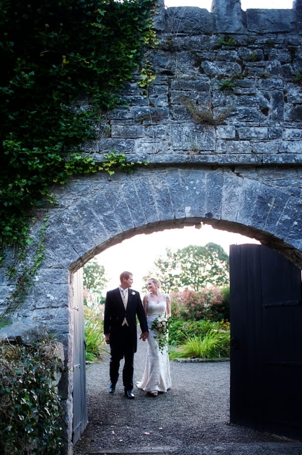 Bride and groom walking through castle grounds