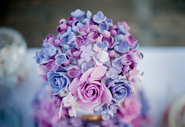 Flowers on top of purple wedding cake